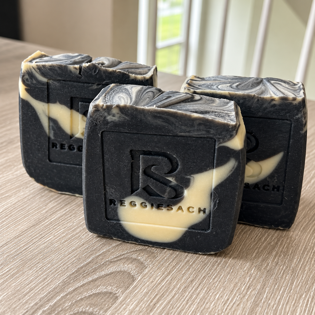 ReggieSach Spooky Vanilla Bar Soap bars stacked on light wood, charcoal and cream marbling with debossed ReggieSach monogram